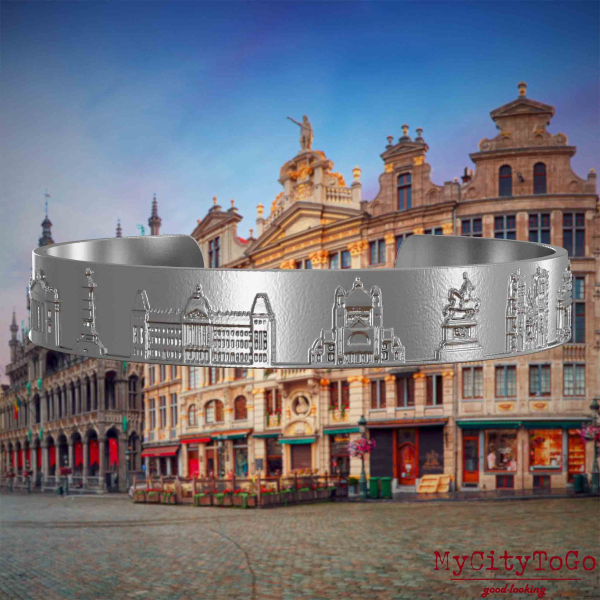 Armreif aus Edelstahl mit Reliefs bekannter Sehenswürdigkeiten der Stadt Brüssel. Den Hintergrund bildet eine Ansicht der Stadt Bruessel.