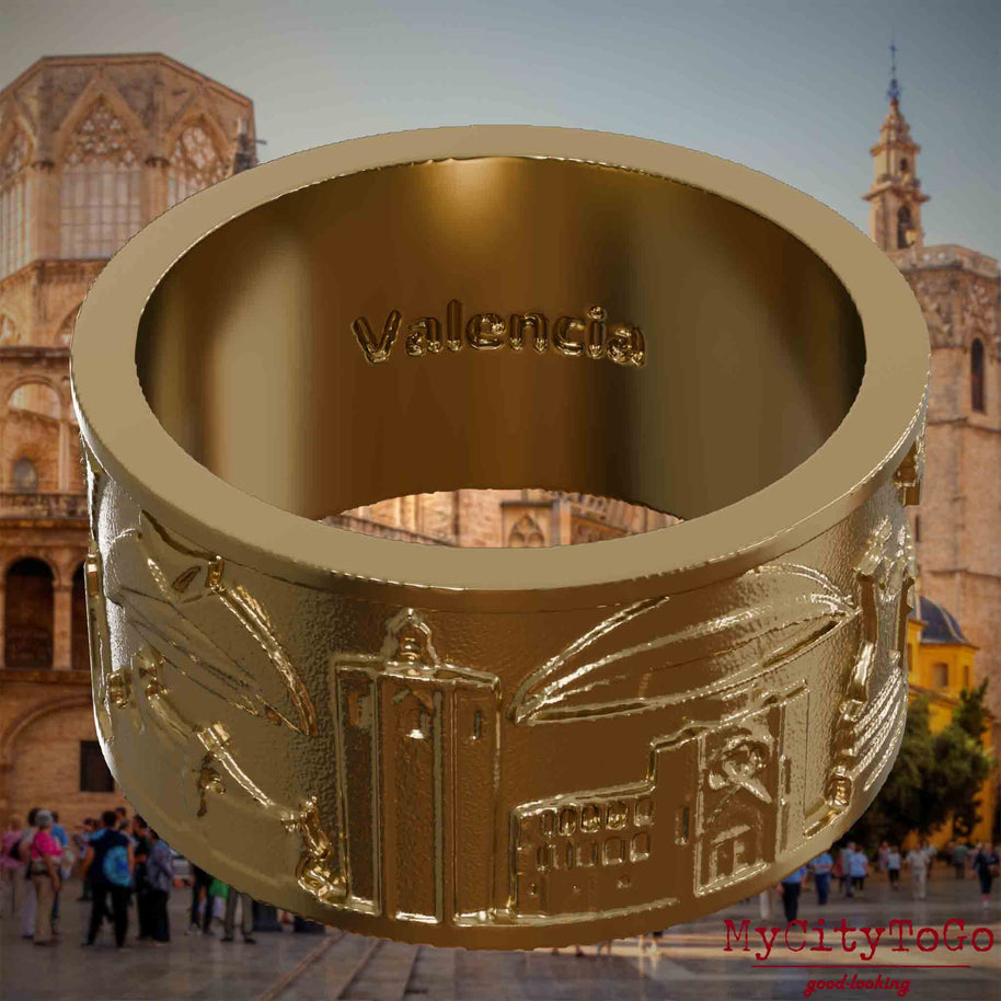Ring aus vergoldetem Edelstahl mit Reliefs bekannter Sehenswürdigkeiten der Stadt Valencia und einer Gravur des Stadtnamens auf der Innenseite. Den Hintergrund bildet eine Ansicht der Stadt Valencia.