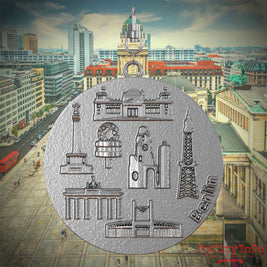 Halskette mit Drehwirbel und Rückseite eines Schmuckanhängers aus Edelstahl, auf dem Reliefs bekannter Sehenswürdigkeiten der Stadt Berlin abgebildet sind. Den Hintergrund bildet eine Ansicht der Stadt Berlin.