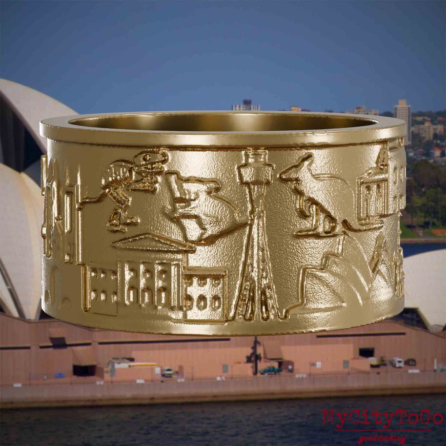 Ring aus vergoldetem Edelstahl mit Reliefs bekannter Sehenswürdigkeiten der Stadt Sydney. Den Hintergrund bildet eine Ansicht der Stadt Sydney.