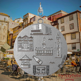 Halskette mit Drehwirbel und Vorderseite eines Schmuckanhängers aus Edelstahl, auf dem Reliefs bekannter Sehenswürdigkeiten der Stadt Porto abgebildet sind. Den Hintergrund bildet eine Ansicht der Stadt Porto.
