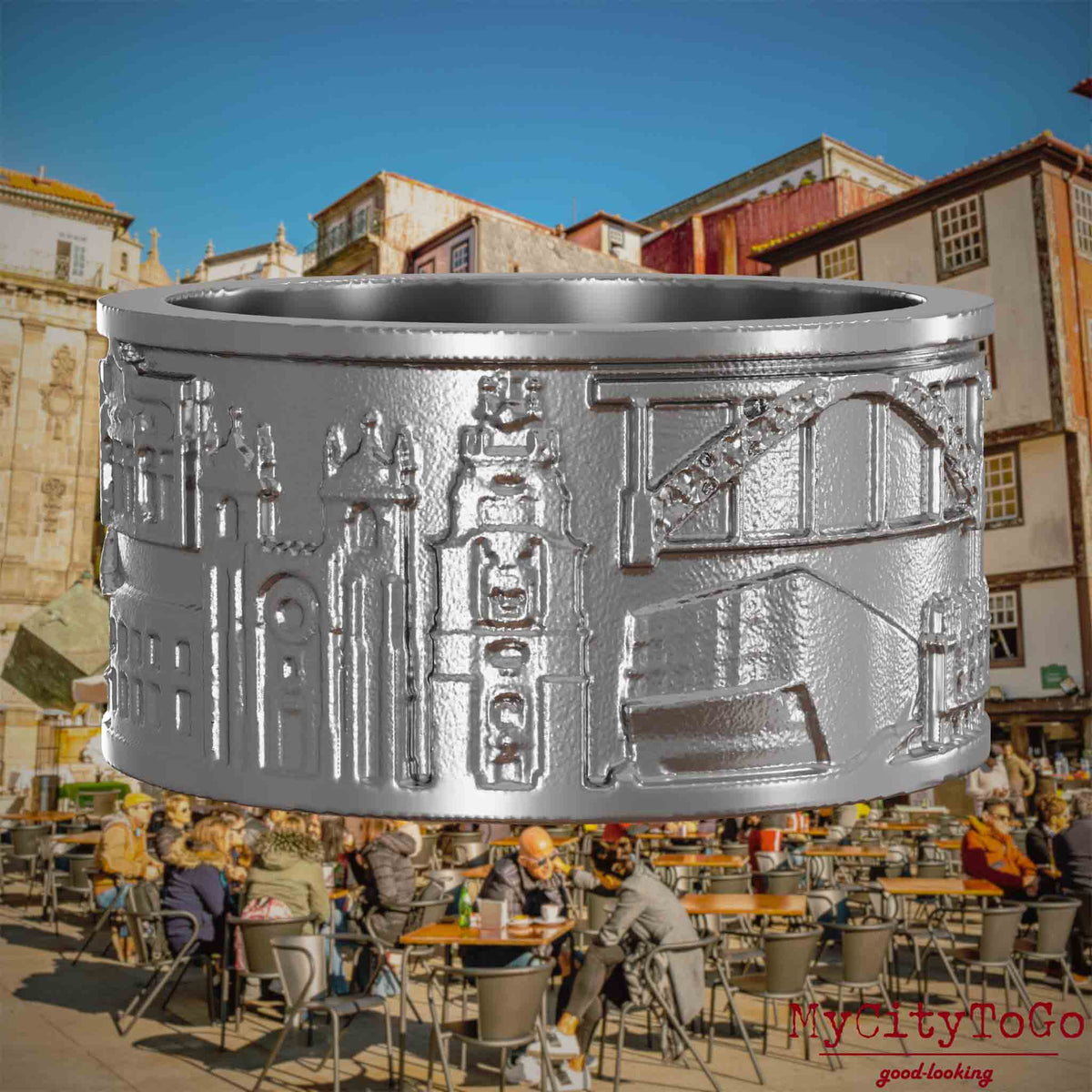 Ring aus Edelstahl mit Reliefs bekannter Sehenswürdigkeiten der Stadt Porto. Den Hintergrund bildet eine Ansicht der Stadt Porto.