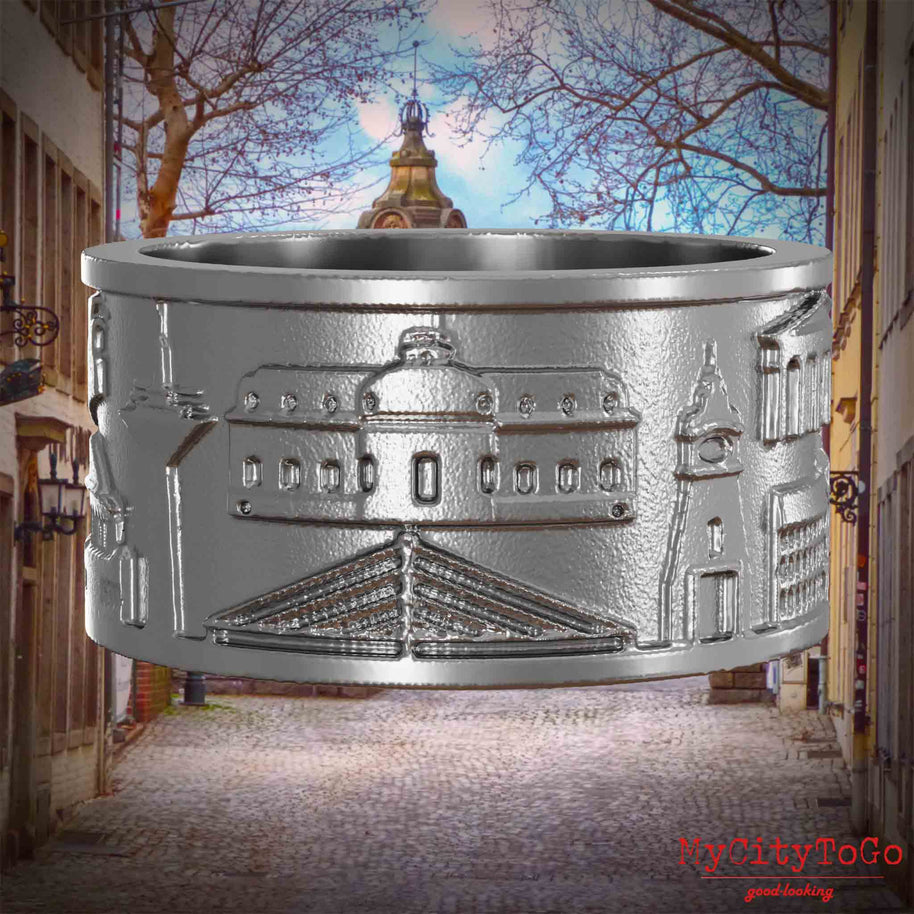 Ring aus Edelstahl mit Reliefs bekannter Sehenswürdigkeiten der Stadt Duesseldorf. Den Hintergrund bildet eine Ansicht der Stadt Duesseldorf.