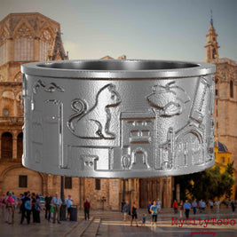 Ring aus Edelstahl mit Reliefs bekannter Sehenswürdigkeiten der Stadt Valencia. Den Hintergrund bildet eine Ansicht der Stadt Valencia.