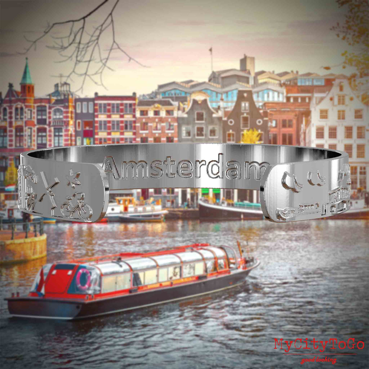 Innenseite eines silbernen Armreifs mit Reliefs bekannter Sehenswürdigkeiten der Stadt Amsterdam und einer Gravur des Stadtnamens. Den Hintergrund bildet eine Ansicht der Stadt Amsterdam.