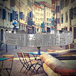 Versilberter Armreif mit Reliefs bekannter Sehenswürdigkeiten der Stadt Zuerich. Den Hintergrund bildet eine Ansicht der Stadt Zuerich.