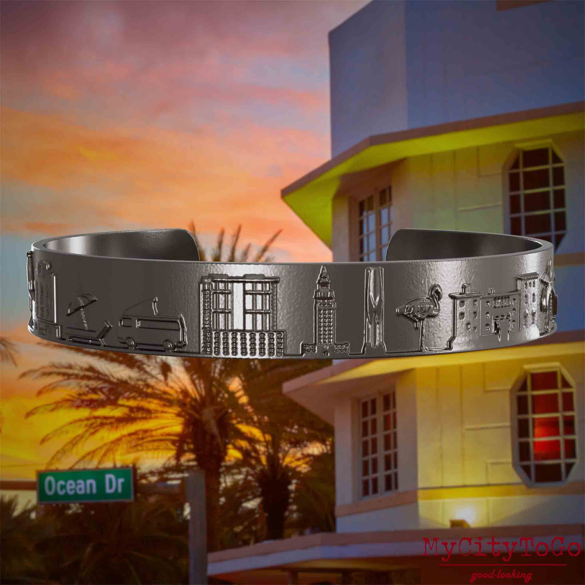 Armreif aus Titan mit Reliefs bekannter Sehenswürdigkeiten der Stadt Miami. Den Hintergrund bildet eine Ansicht der Stadt Miami.