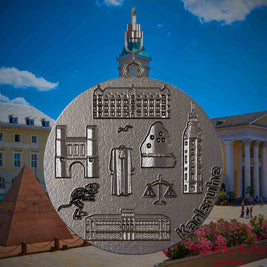 Halskette mit Drehwirbel und Rückseite eines Schmuckanhängers aus Titan, auf dem Reliefs bekannter Sehenswürdigkeiten der Stadt Karlsruhe abgebildet sind. Den Hintergrund bildet eine Ansicht der Stadt Karlsruhe .
