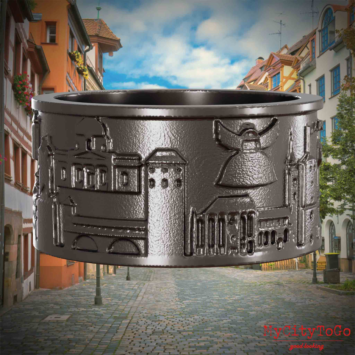 Ring aus Titan mit Reliefs bekannter Sehenswürdigkeiten der Stadt Nuernberg. Den Hintergrund bildet eine Ansicht der Stadt  Nuernberg.