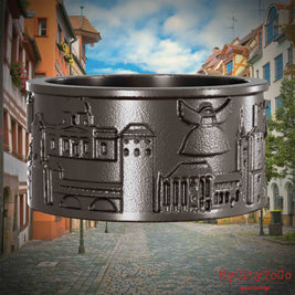 Ring aus Titan mit Reliefs bekannter Sehenswürdigkeiten der Stadt Nuernberg. Den Hintergrund bildet eine Ansicht der Stadt  Nuernberg.