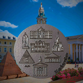 Halskette mit Drehwirbel und Vorderseite eines Schmuckanhängers aus Titan, auf dem Reliefs bekannter Sehenswürdigkeiten der Stadt Karlsruhe abgebildet sind. Den Hintergrund bildet eine Ansicht der Stadt Karlsruhe .
