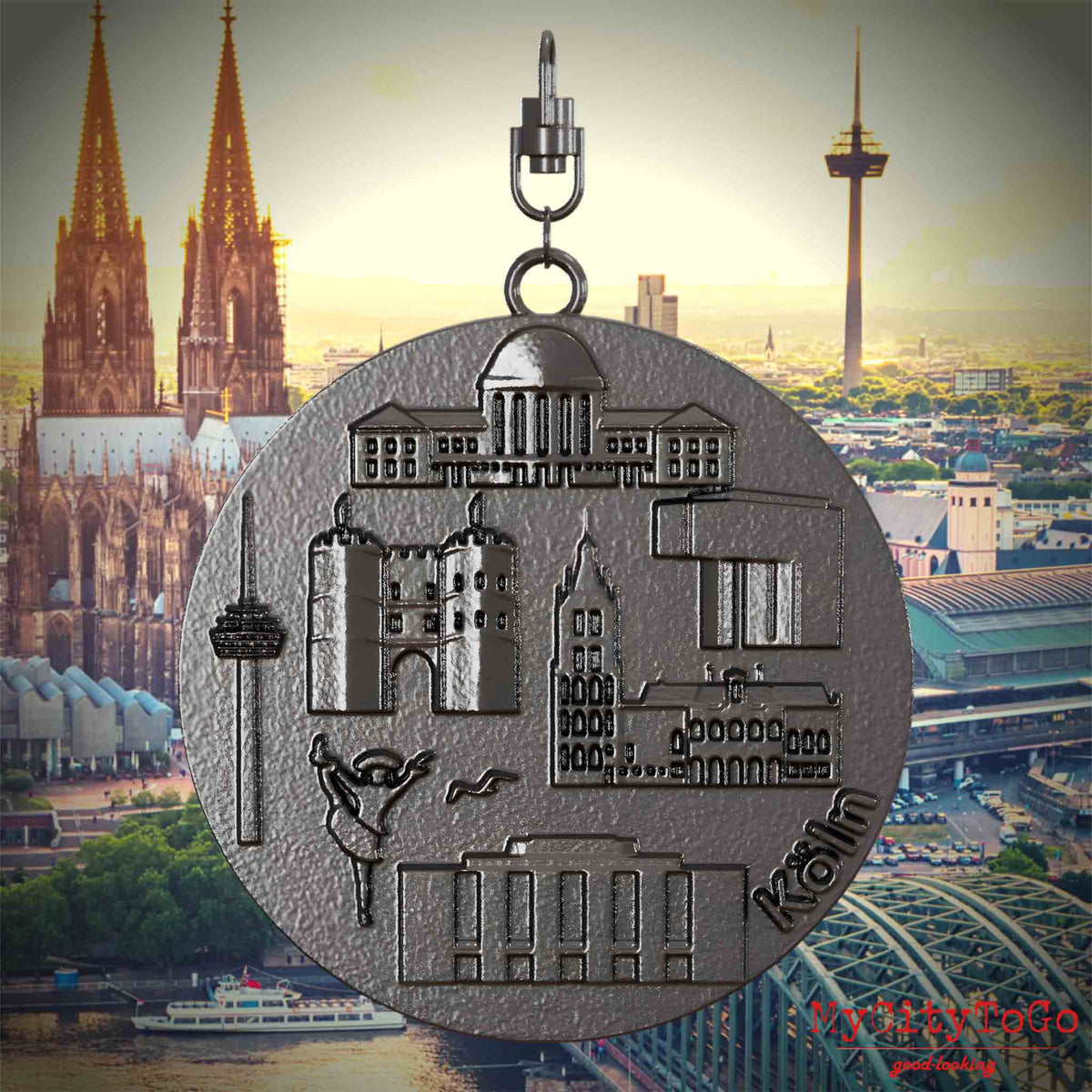 Halskette mit Drehwirbel und Rückseite eines Schmuckanhängers aus Titan, auf dem Reliefs bekannter Sehenswürdigkeiten der Stadt Koeln abgebildet sind. Den Hintergrund bildet eine Ansicht der Stadt Koeln.