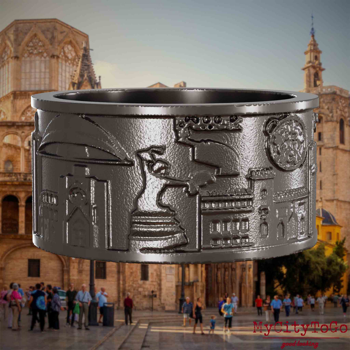 Ring aus Titan mit Reliefs bekannter Sehenswürdigkeiten der Stadt Valencia. Den Hintergrund bildet eine Ansicht der Stadt Valencia.