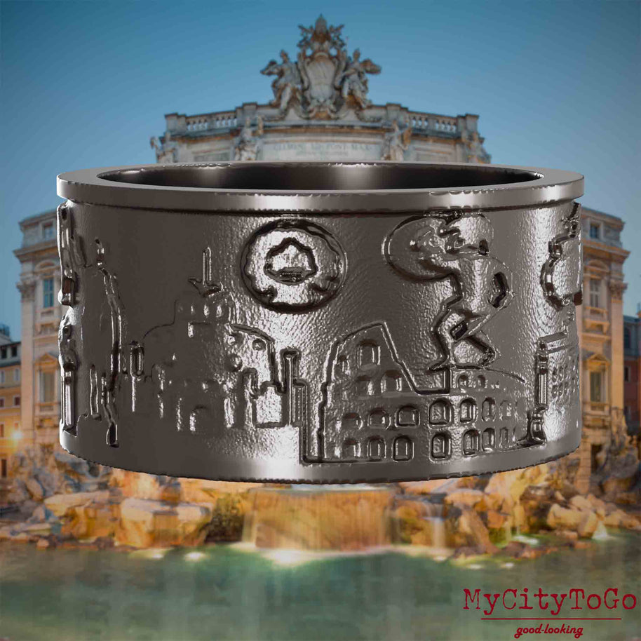 Ring aus Titan mit Reliefs bekannter Sehenswürdigkeiten der Stadt Rom. Den Hintergrund bildet eine Ansicht der Stadt Rom.