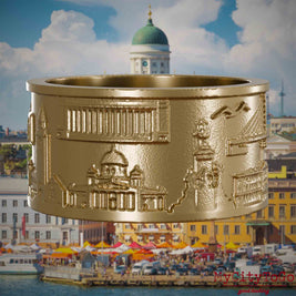 Ring aus vergoldetem Edelstahl mit Reliefs bekannter Sehenswürdigkeiten der Stadt Helsinki. Den Hintergrund bildet eine Ansicht der Stadt Helsinki.