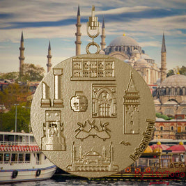 Halskette mit Drehwirbel und Rückseite eines Schmuckanhängers aus vergoldetem Edelstahl, auf dem Reliefs bekannter Sehenswürdigkeiten der Stadt Istanbul abgebildet sind. Den Hintergrund bildet eine Ansicht der Stadt Istanbul.
