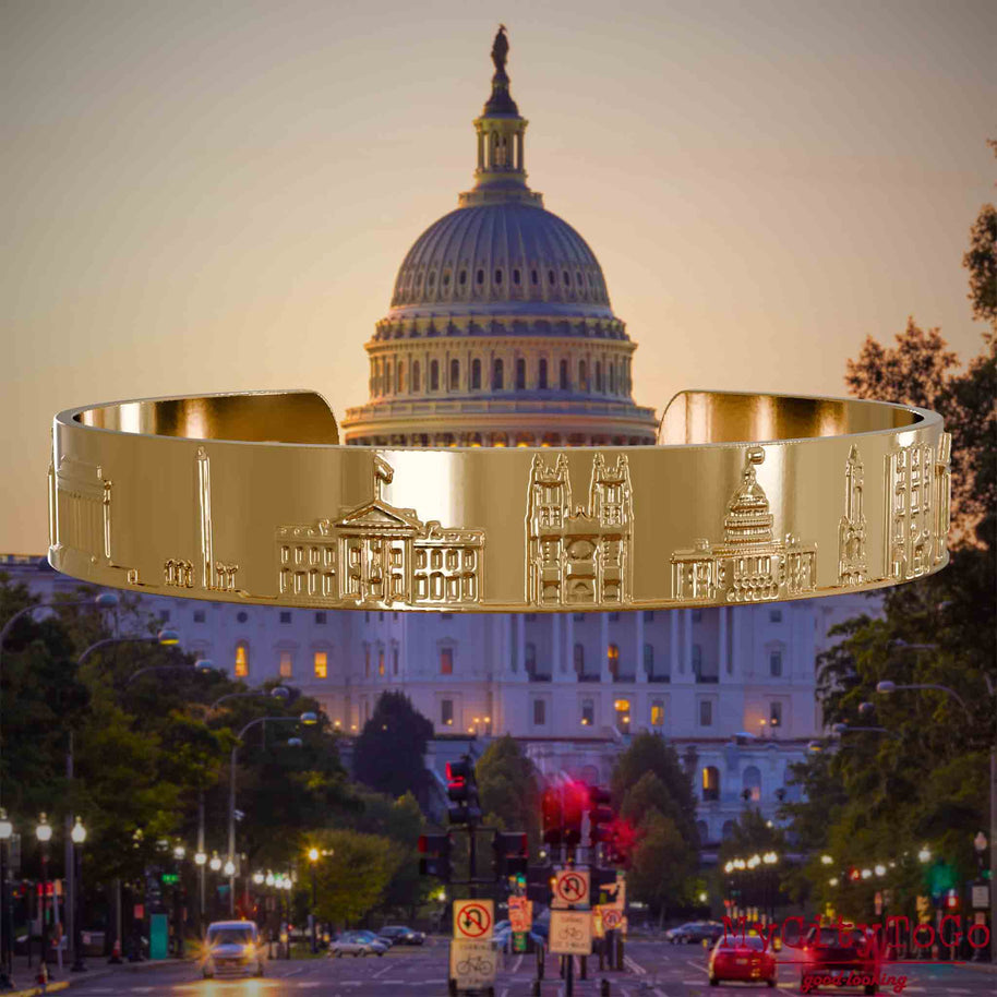 Vergoldeter Armreif mit Reliefs bekannter Sehenswürdigkeiten der Stadt Washington. Den Hintergrund bildet eine Ansicht der Stadt Washington.