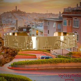 Vergoldeter Armreif mit Reliefs bekannter Sehenswürdigkeiten der Stadt San Francisco. Den Hintergrund bildet eine Ansicht der Stadt San Francisco.