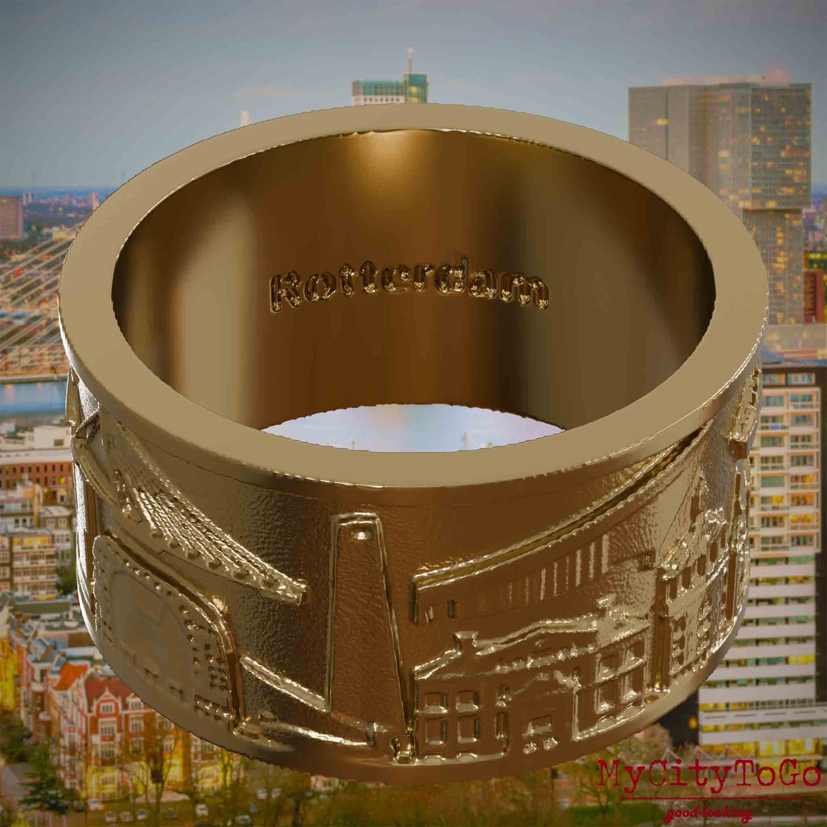 Ring aus vergoldetem Edelstahl mit Reliefs bekannter Sehenswürdigkeiten der Stadt Rotterdam und einer Gravur des Stadtnamens auf der Innenseite. Den Hintergrund bildet eine Ansicht der Stadt Rotterdam.