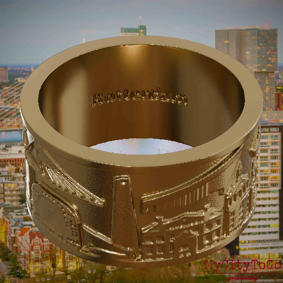 Ring aus vergoldetem Edelstahl mit Reliefs bekannter Sehenswürdigkeiten der Stadt Rotterdam und einer Gravur des Stadtnamens auf der Innenseite. Den Hintergrund bildet eine Ansicht der Stadt Rotterdam.