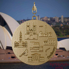 Halskette mit Drehwirbel und Rückseite eines Schmuckanhängers aus vergoldetem Edelstahl, auf dem Reliefs bekannter Sehenswürdigkeiten der Stadt Sydney abgebildet sind. Den Hintergrund bildet eine Ansicht der Stadt Sydney.
