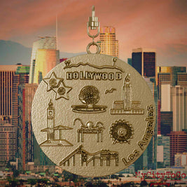 Halskette mit Drehwirbel und Vorderseite eines Schmuckanhängers aus vergoldetem Edelstahl, auf dem Reliefs bekannter Sehenswürdigkeiten der Stadt Los Angeles abgebildet sind. Den Hintergrund bildet eine Ansicht der Stadt Los Angeles.
