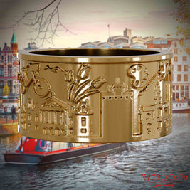 Vergoldeter Ring mit Reliefs bekannter Sehenswürdigkeiten der Stadt Amsterdam. Den Hintergrund bildet eine Ansicht der Stadt Amsterdam.