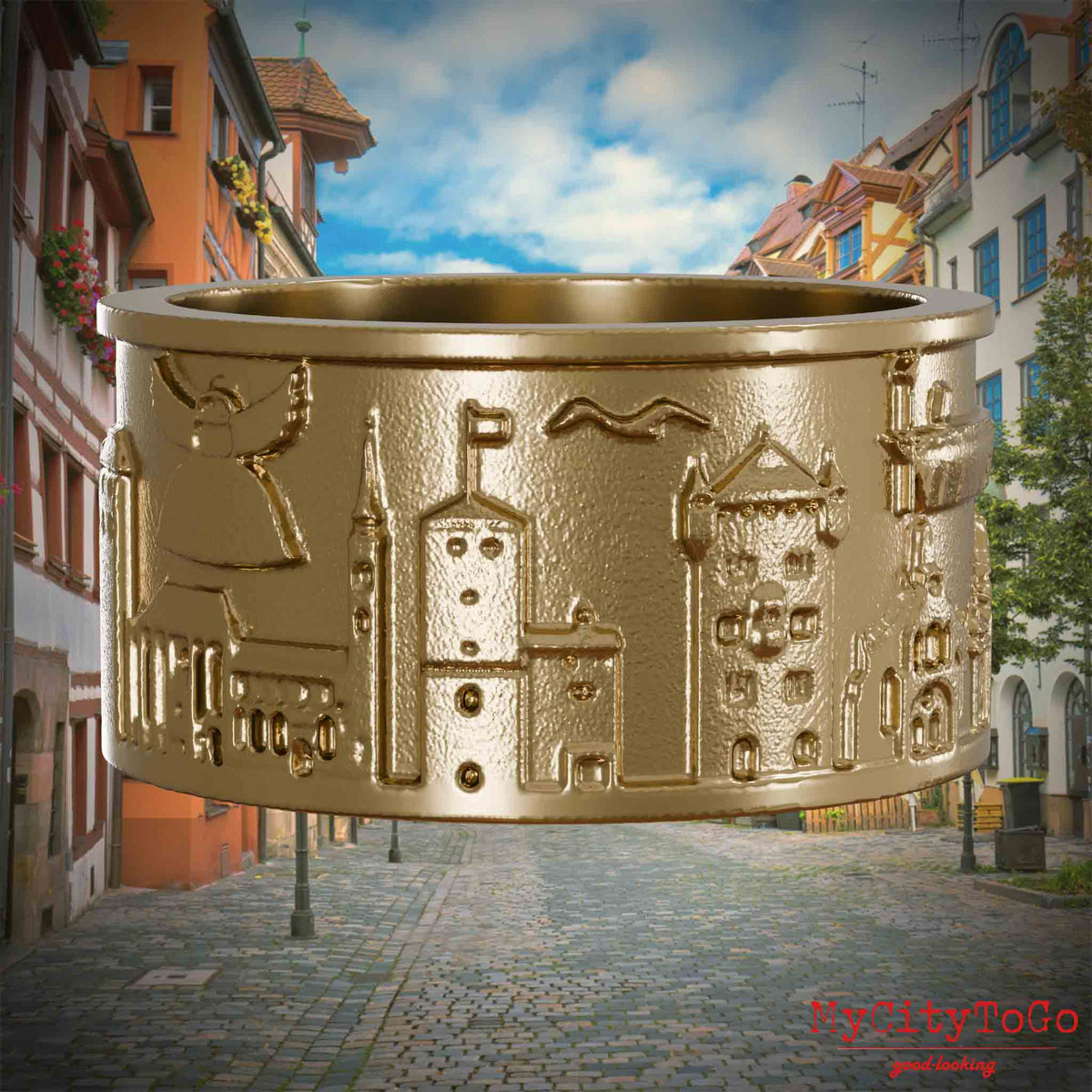 Ring aus vergoldetem Edelstahl mit Reliefs bekannter Sehenswürdigkeiten der Stadt Nuernberg. Den Hintergrund bildet eine Ansicht der Stadt  Nuernberg.