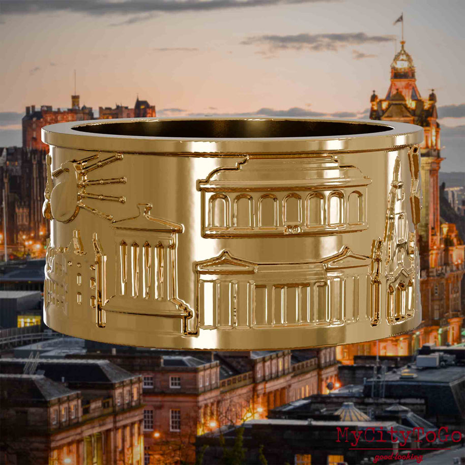 Vergoldeter Ring mit Reliefs bekannter Sehenswürdigkeiten der Stadt Edinburgh. Den Hintergrund bildet eine Ansicht der Stadt Edinburgh.
