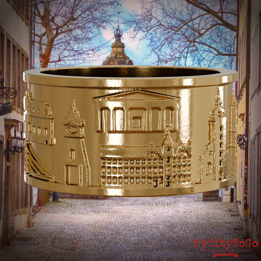 Vergoldeter Ring mit Reliefs bekannter Sehenswürdigkeiten der Stadt Duesseldorf. Den Hintergrund bildet eine Ansicht der Stadt Duesseldorf.