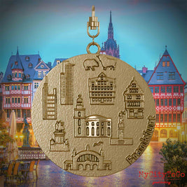 Halskette mit Drehwirbel und Vorderseite eines Schmuckanhängers aus vergoldetem Edelstahl, auf dem Reliefs bekannter Sehenswürdigkeiten der Stadt Frankfurt abgebildet sind. Den Hintergrund bildet eine Ansicht der Stadt Frankfurt.
