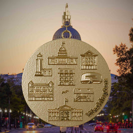 Halskette mit Drehwirbel und Rückseite eines Schmuckanhängers aus vergoldetem Edelstahl, auf dem Reliefs bekannter Sehenswürdigkeiten der Stadt Washington abgebildet sind. Den Hintergrund bildet eine Ansicht der Stadt Washington.
